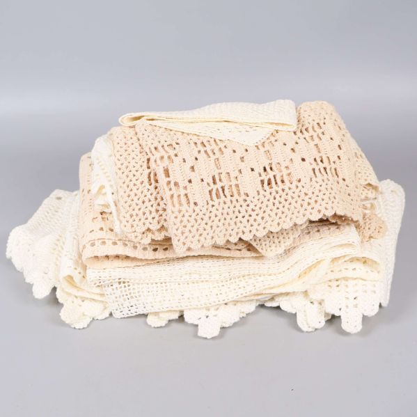 Hög med virkade spetsdukar i beige och vitt