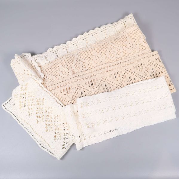  beige och vit virkad spets liggande bredvid varandra