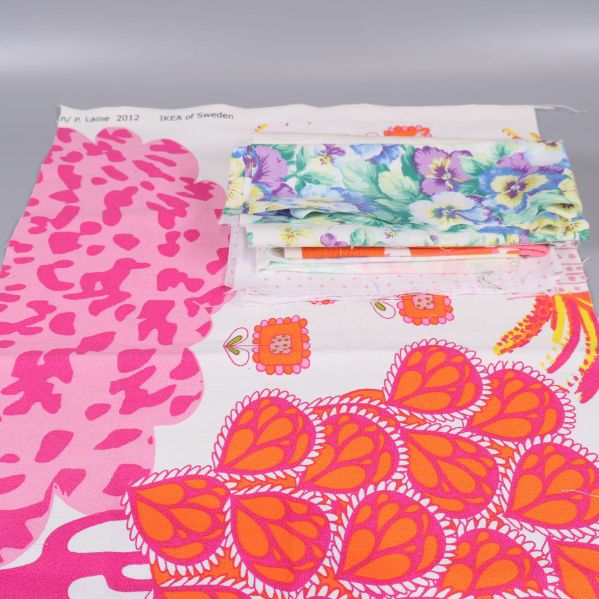 Stora och små tygbitar med rosa, orange och blommiga motiv