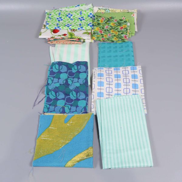 Tygbitar i blått, grönt och vitt upplagda på rad