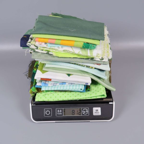 Staplad hög med stuvbitar vägs på digital våg