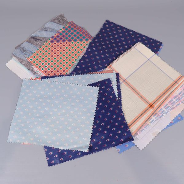 Flera tygprover i blå toner med små tryckta motiv och rutiga mönster