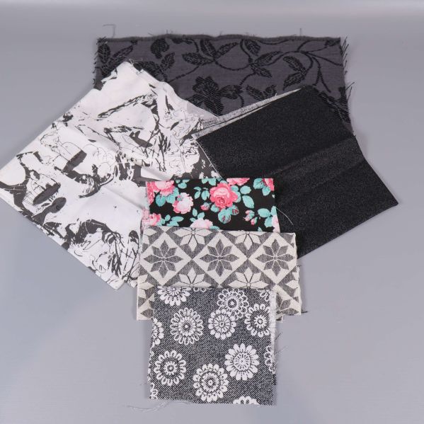 Svartvita och blommiga tygbitar ordnade i grupp