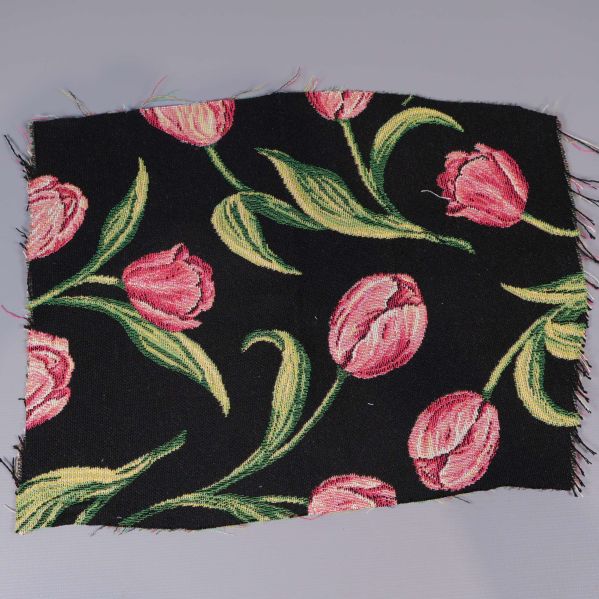 Närbild på svart tyg med rosa tulpanmönster