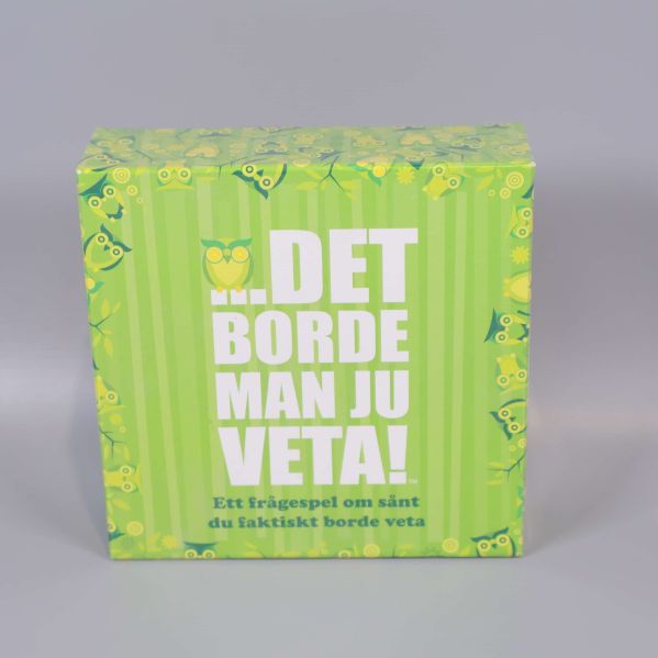 Framsidan på grön sällskapsspelsask med ugglor och text