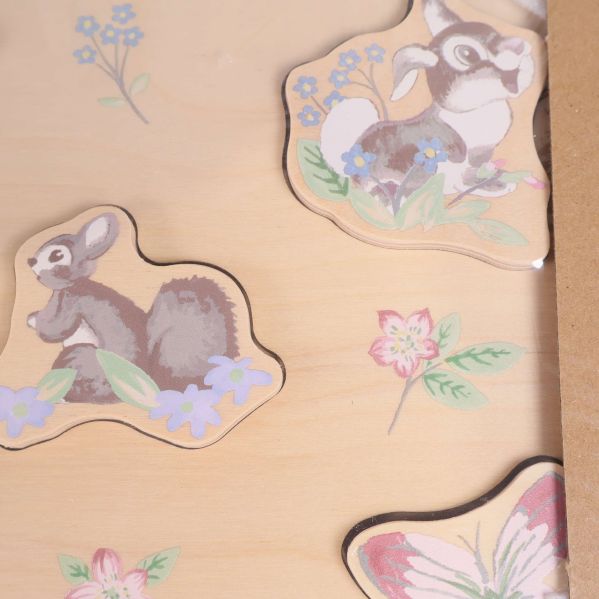 Närbild på två bitar från babypusslet med blommotiv