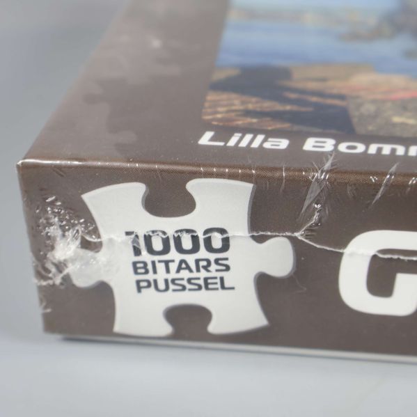 Närbild av pussellåda med texten 1000 bitars pussel tryckt på sidan
