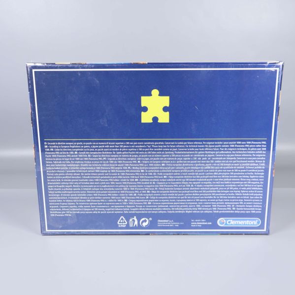 Baksida av pussellåda i blått med pusselbit-symbol