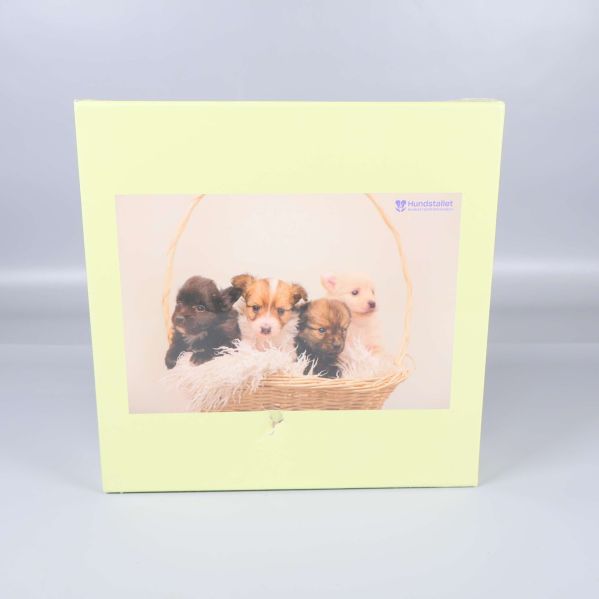 Pusselask med motiv av fyra hundvalpar i korg