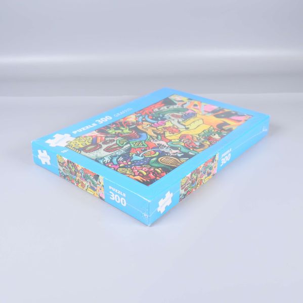 Pusselask med graffiti motiv i blå ram fotad från sidan