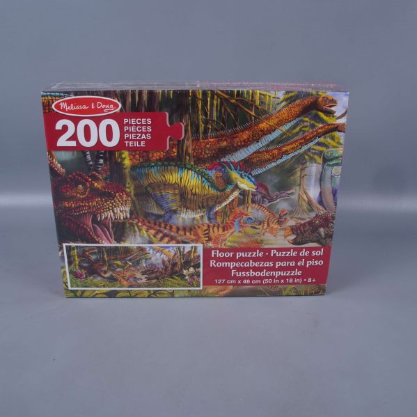 Framsidan av pusselask med dinosauriemotiv och texten 200 bitar