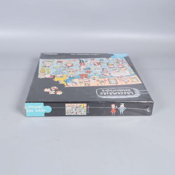 Nedre sidan av pusselasken med motiv och logotyp