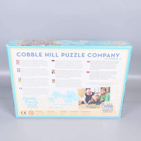 Baksidan av pussellåda med information om Cobble Hill Puzzle Company