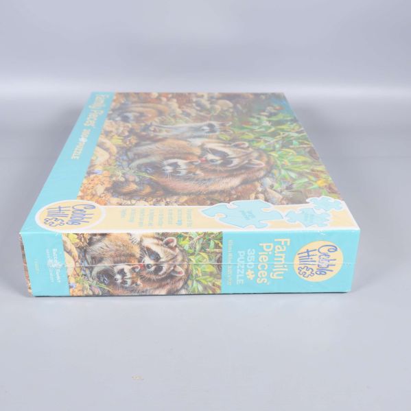 Närbild av pussellådans kortsida som visar motiv och logga