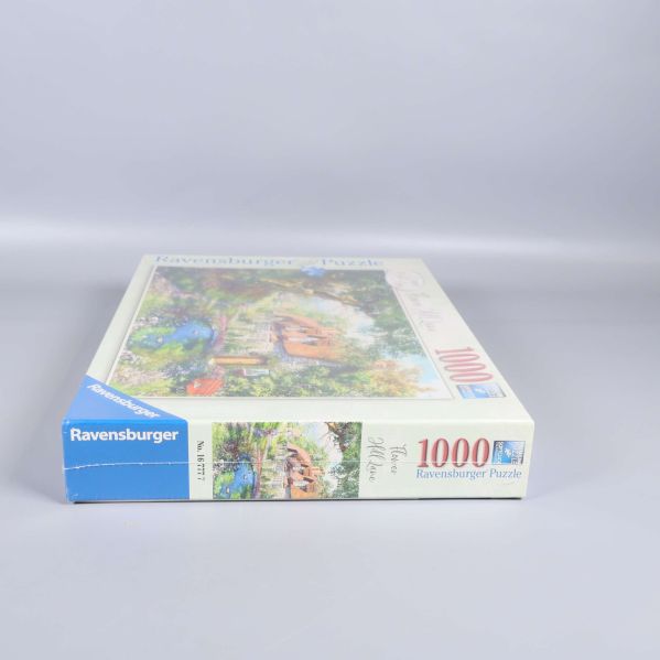 Pussellåda sedd från blå hörn med Ravensburger-logotyp