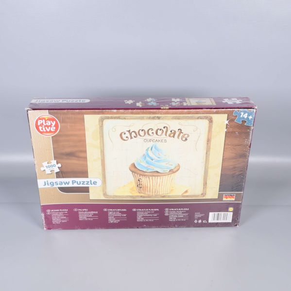 Baksidan av pussellåda med cupcake och texten Chocolate