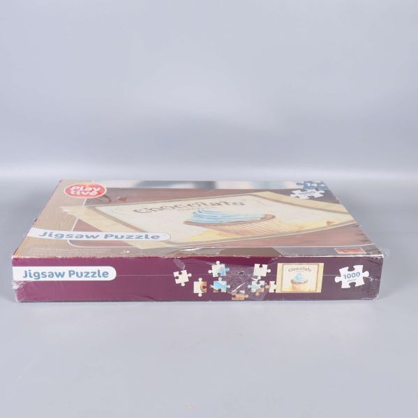 Sidan av pussellådan med texten Jigsaw Puzzle och cupcake-motiv