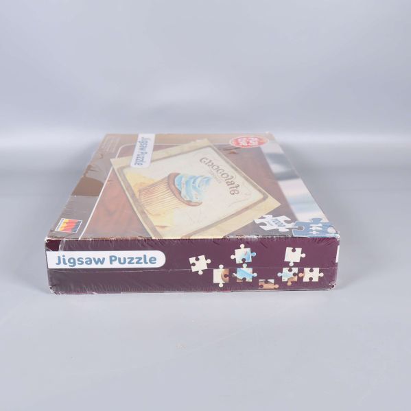 Kortända av pussellådan med Jigsaw Puzzle-text och pusselbitar