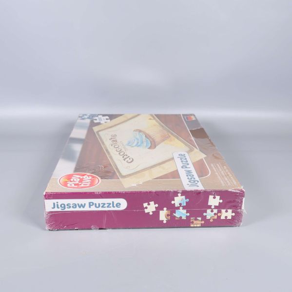 Andra kortsidan av pussellådan med texten Jigsaw Puzzle