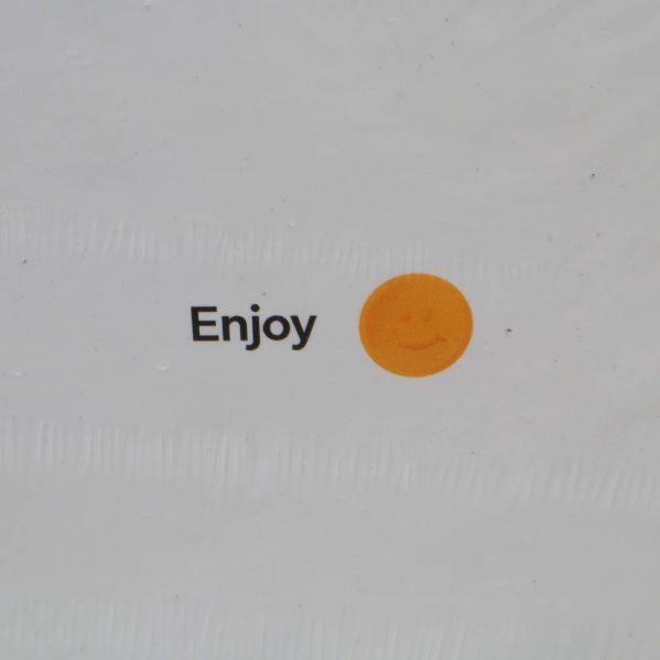 Närbild på gul smiley och texten Enjoy på baksidan