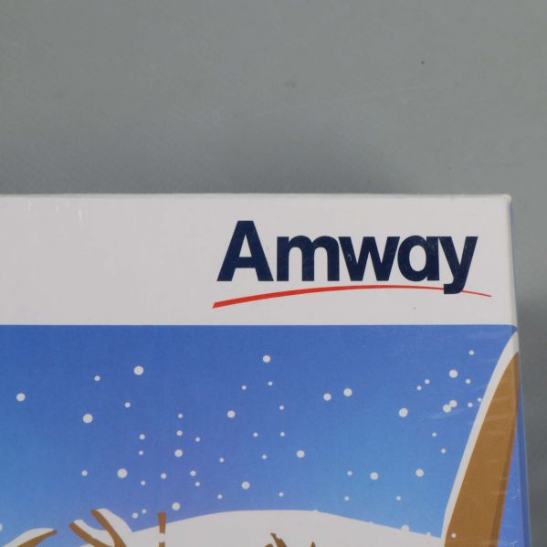 Närbild på Amway-logotypen i hörnet av lådan