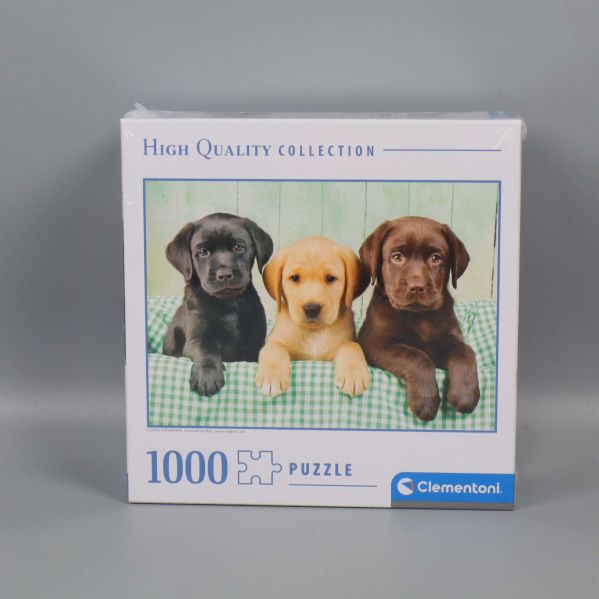 Framsidan av pussellåda med tre labradorvalpar