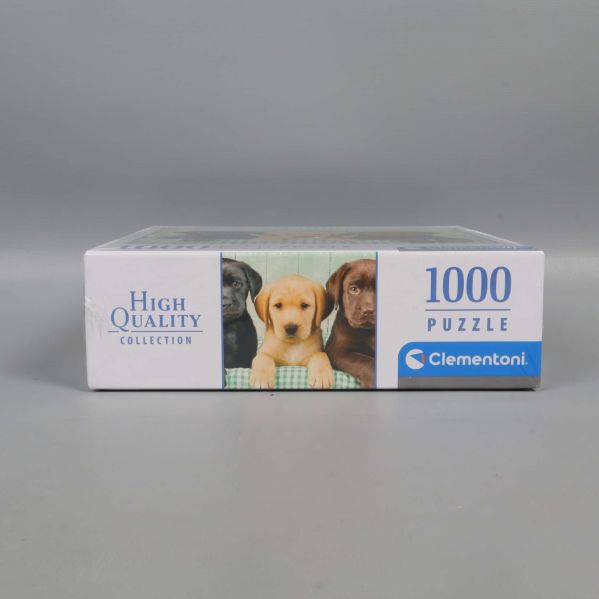 Undersidan av pussellåda med valpmotiv och Clementoni-logotyp