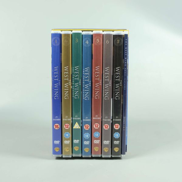 Alla sju West Wing DVD-fodral bredvid varandra upprätt
