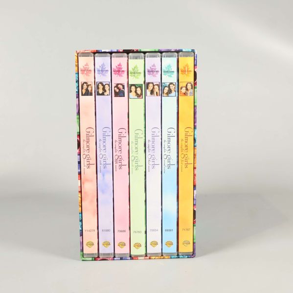 Sju DVD-fodral i olika färger staplade lodrätt i boxen