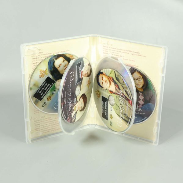 Öppet DVD-fodral med fyra Gilmore Girls-skivor i hållare