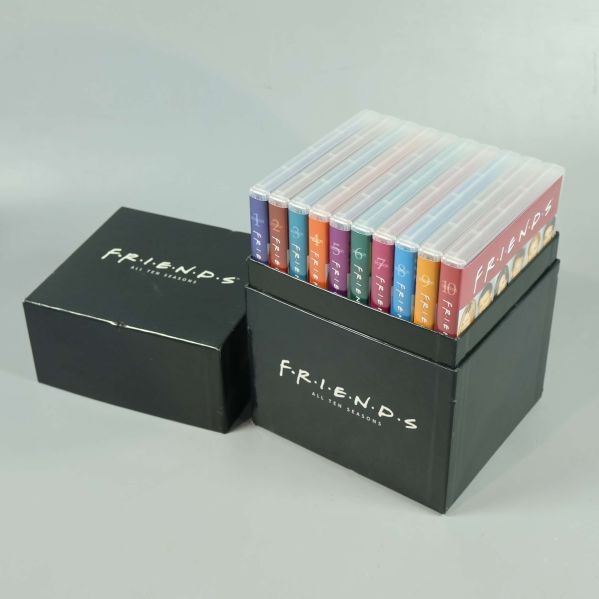 Friends samlingsbox öppen med färgglada dvd-fodral i boxen