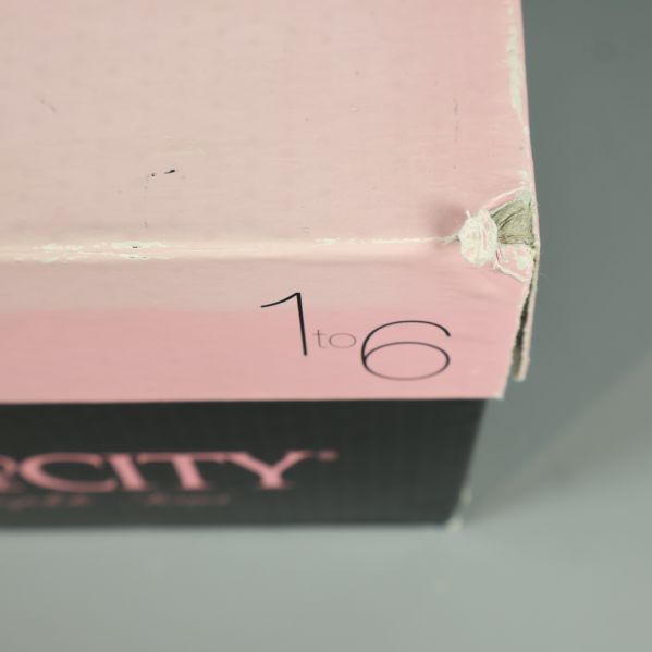 Närbild på skadat hörn av Sex and the City DVD-box