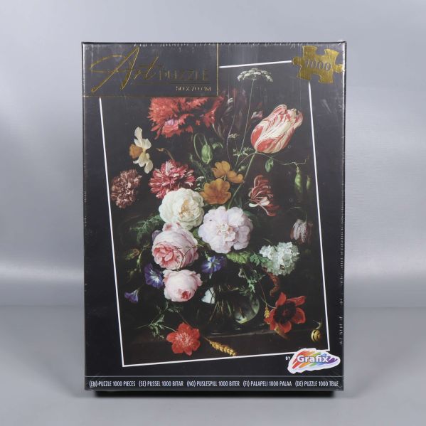 Framsidan av pussellådan med blomstermotiv och Grafix-logga