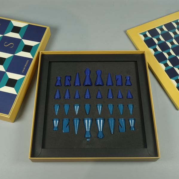 Schackpjäser i blå färg ligger ordnade i lådan