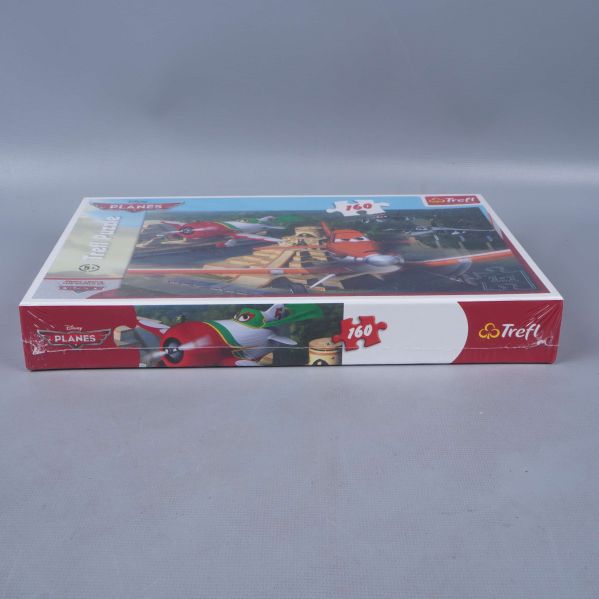 Långsida av pussellåda med motiv och märkning