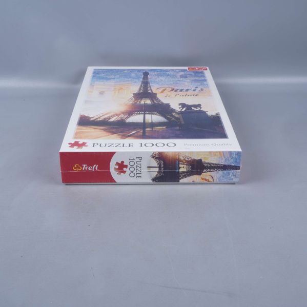 Kortkant på pussellåda med motiv och logga