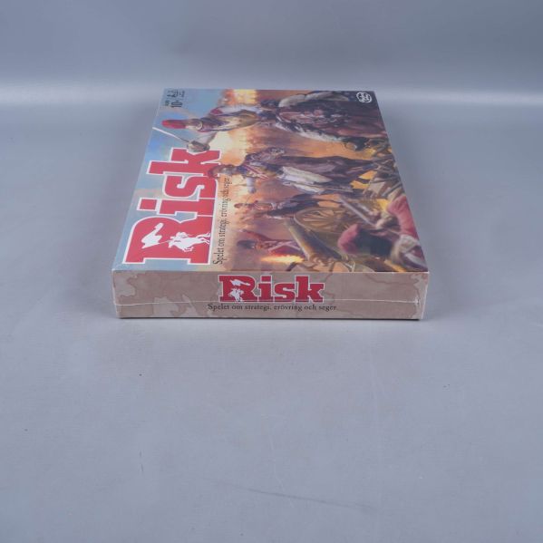 Risk spelkartongen i vinkel, logotypen synlig
