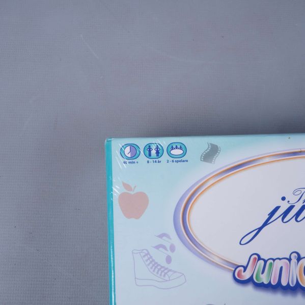 Hörndetalj av ask där spelinformation och åldersrekommendation visas