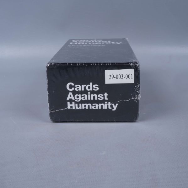 Kortände av spelbox med etikett och Cards Against Humanity text
