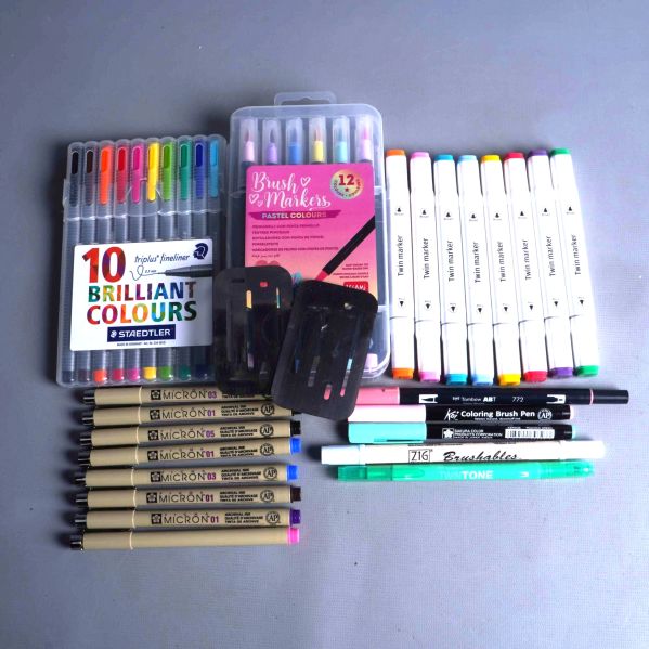 Översikt av markers, fineliners och metallmallar upplagda