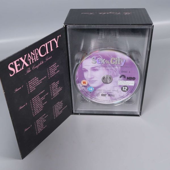 Öppen DVD-box med synlig Sex and the City-skiva