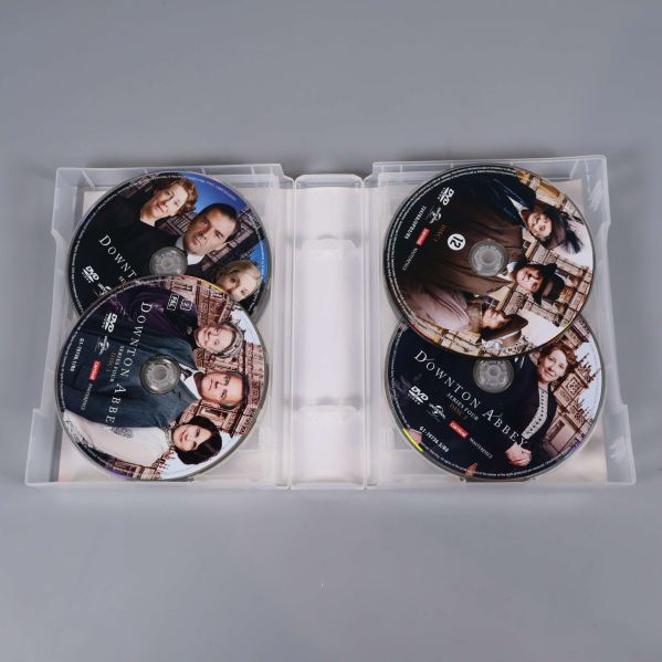Öppen DVD-box med flera Downton Abbey-skivor