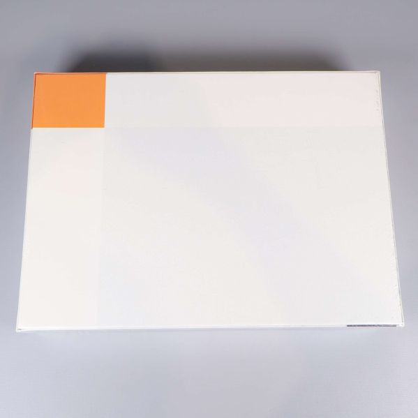 Baksida på pusselkartong, helt vit med orange hörn