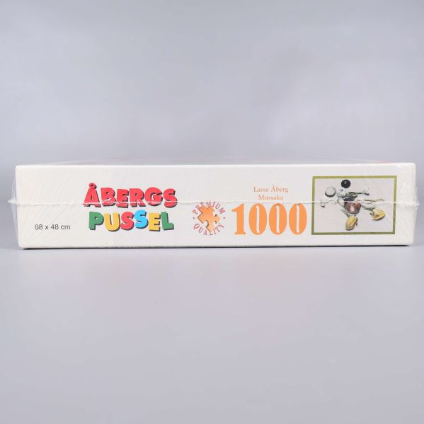 Sida av kartong med Åbergs pussel logotyp och 1000 bitar