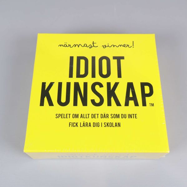 Framsida av spelbox med texten Idiotkunskap på gul bakgrund