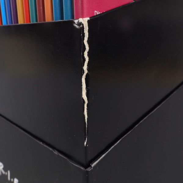 Närbild på slitage och repa vid hörn av Friends-boxen