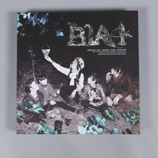 Framsidan av k-pop album med bandmedlemmar och blommotiv