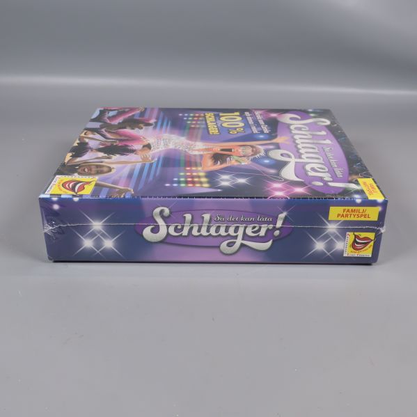 Schlager spelkartong sedd från andra sidan med text och logga