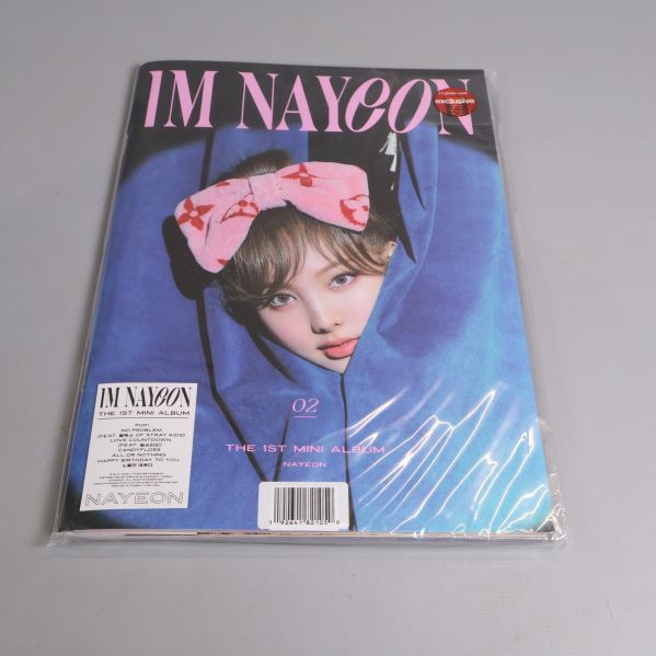 Närbild på Im Nayeon-albumet med blått omslag och rosa rosett