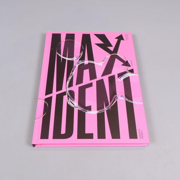 Stängd rosa fotobok med svart text MAXIDENT på framsidan